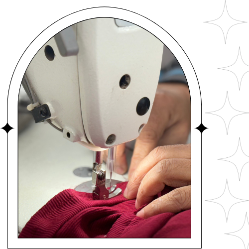 person is focused on sewing a bright red shirt
